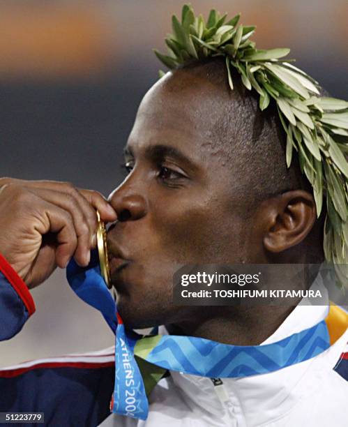 Men's long jump gold winner Dwight Phillips of the USA kisses his medal, 26 August 2004, during the Olympic Games athletics competitions at the...