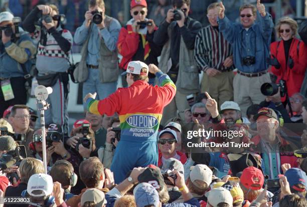 Jeff Gordon of DuPont Chevrolet celebrates winning the Winston Cup championship in the NASCAR NAPA 500 at the Atlantic Motor Speedway on November 12,...