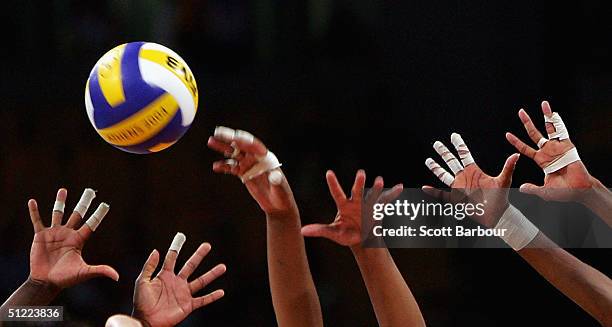 Players hands reach for the ball at the net during the China v Cuba women's indoor Volleyball semifinal match on August 26, 2004 during the Athens...