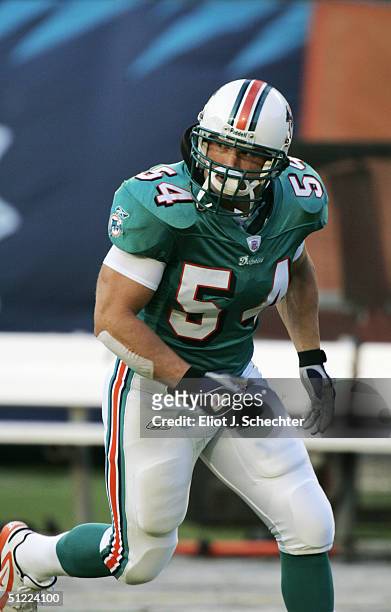Zach Thomas of the Miami Dolphins warms up before the preseason NFL game against the Washington Redskins on August 21, 2004 at Pro Player Stadium in...