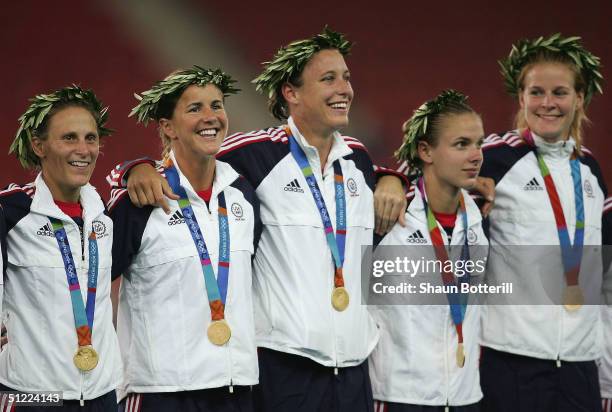 Members of the victorious USA team stand on the podium with their Gold medals while singing the American national anthem during the medal ceremony...