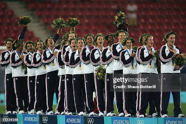 Members of the victorious USA team stand on the podium with their Gold medals while singing the American national anthem during the medal ceremony...