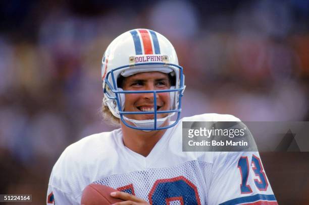 Quarterback Dan Marino of the Miami Dolphins smiles as he holds the ball during a game against the Atlanta Falcons in 1986 at Pro Player Stadium in...