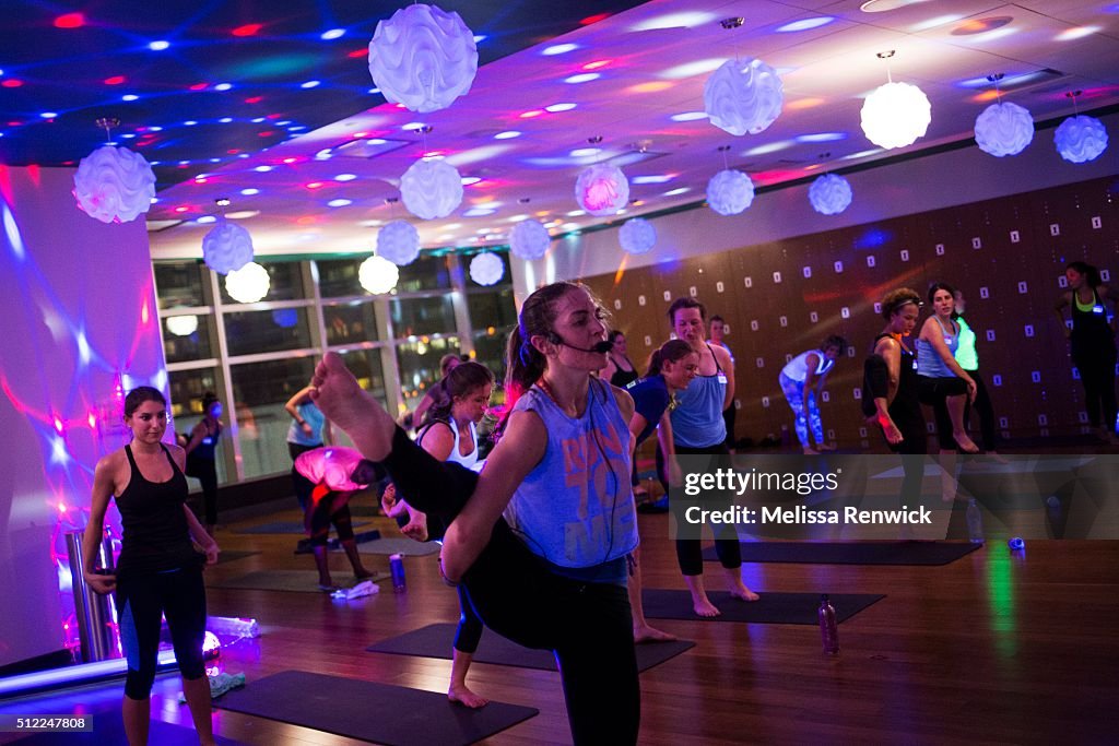 Megan Leach teaches a black light yoga class at Hard Candy Fitness during a "sweat working" event for women.