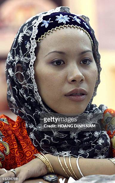 Cham girl stands behind an stall of souvenir items during the opening ceremony of Cham cultural Days in Hanoi, 27 August 2004. The Cham people are...