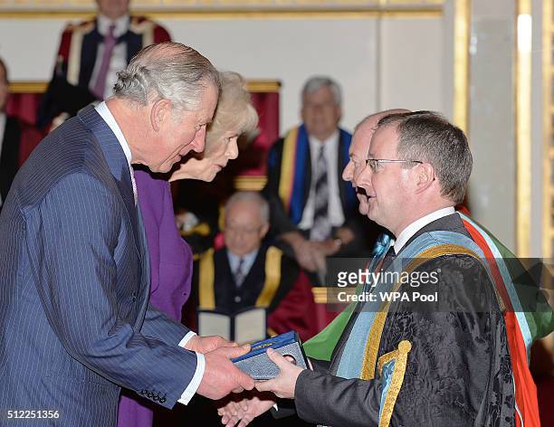 Prince Charles, Prince of Wales and Camilla, Duchess of Cornwall speak with Professor Patrick Johnston of Queen's University Belfast, during the...
