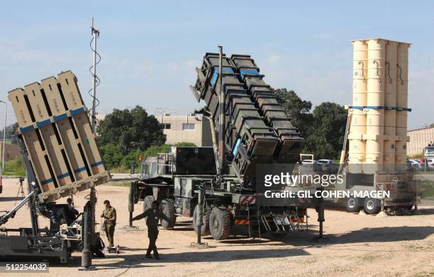 Israeli soldiers walk near an Israeli Irone Dome defence system , a surface-to-air missile system, the MIM-104 Patriot , and an anti-ballistic...