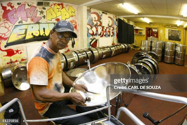 Steel Pan tuner Dudley Dickson checks a strobe machine as he tunes the first of the Ebony Steel band's 300 steel pan drums, left to tune in his...