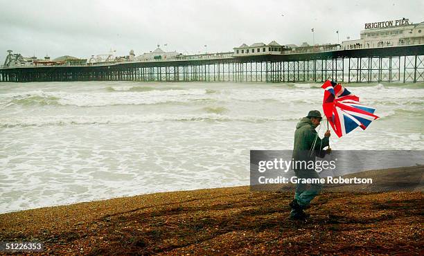 In this photo illustration a lone figure braves the elements, August 27, 2004 on the seafront at Brighton on England's south coast. Traditionally the...