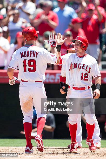 David Murphy of the Los Angeles Angels is greeted by teammate Johnny Giavolella after scoring a run during the game against the Baltimore Orioles at...