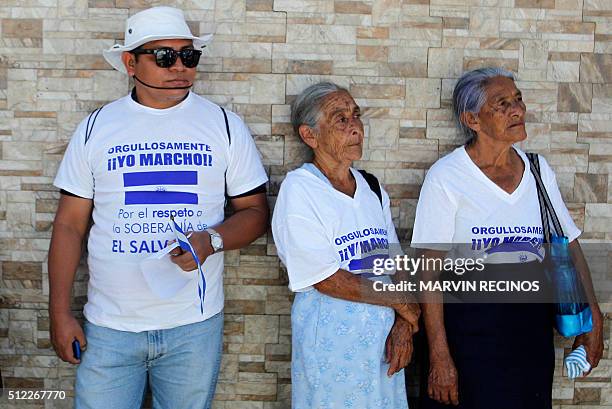 Relatives of military personnel required in Spain for their link to the 1989 murders of six Jesuit priests, are pictured during a march to the...