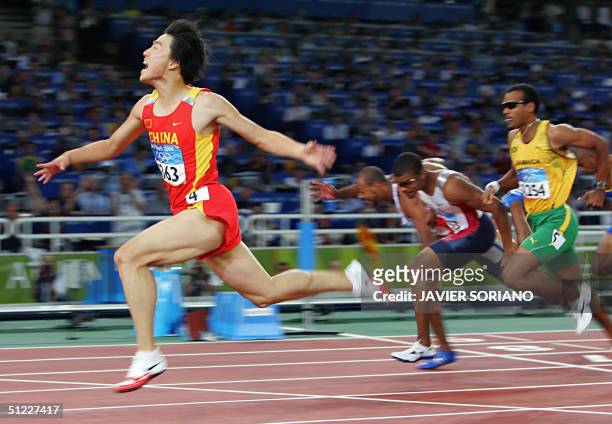 China's Liu Xiang celebrates as he wins the men's 110m hurdles final ahead of USA's Terence Trammell and Jamaica's Maurice Wignall , at the Olympic...
