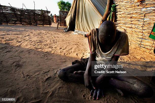 Blind and mentally handicapped Sudanese refugee boy who recently fled with his family from conflict in the Dafur region of Sudan, sits in a corner...