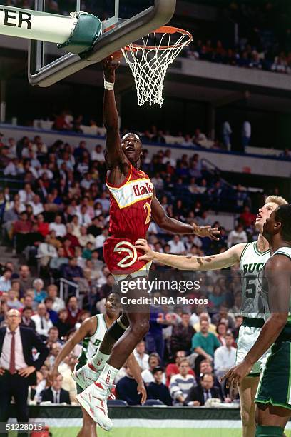 Dominique Wilkins of the Atlanta Hawks drives to the basket for a layup against the Milwaukee Bucks during an NBA game in 1990 at Bradley Center in...