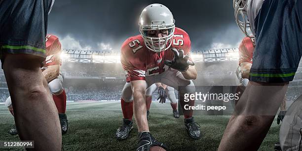 アメリカンフットボールに不快なラインの中央にスナップ式ボール - アメリカンフットボールラインマン ストックフォトと画像