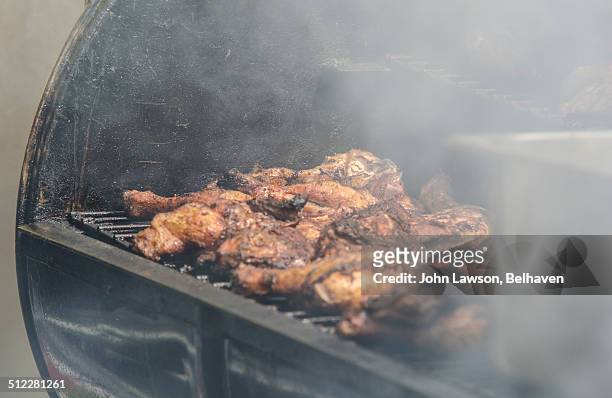 jerk chicken cooking in an oil drum barbeque - jerk chicken stock pictures, royalty-free photos & images