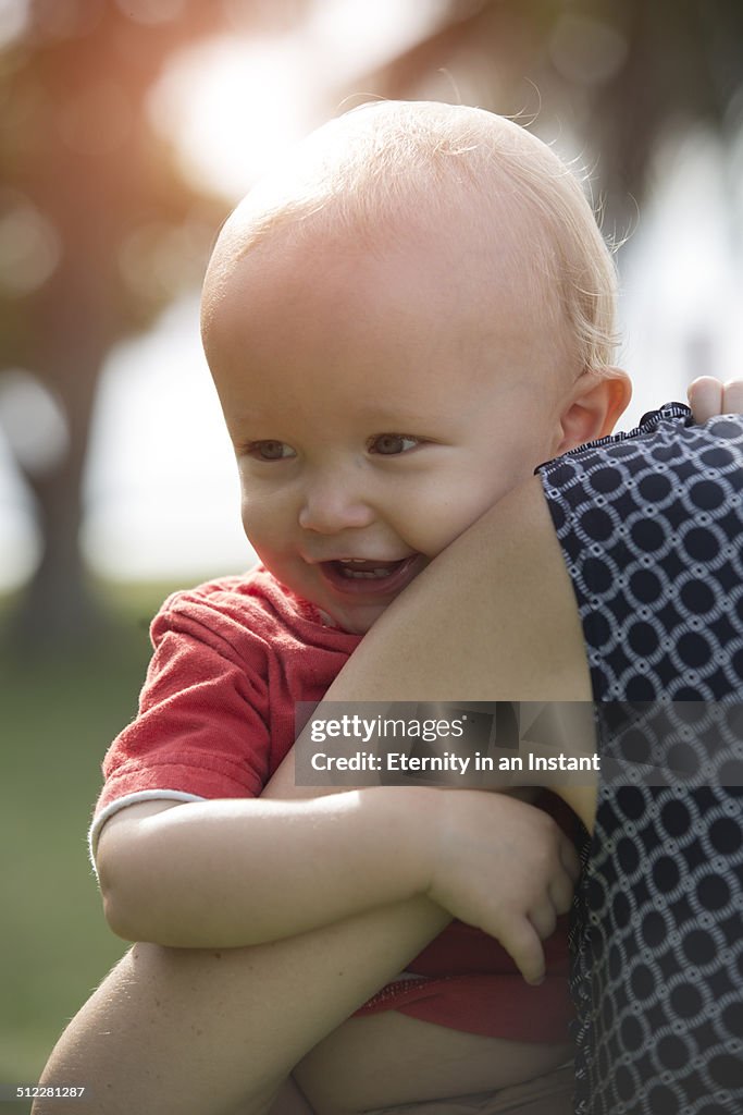 Smiling baby being held by mother