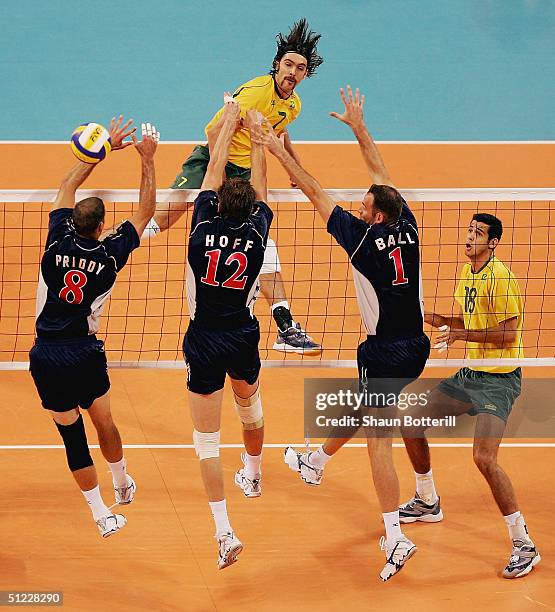 Gilberto Godoy Filho of Brazil sends the ball through the defense of William Priddy, Thomas Hoff and Lloy Ball of the United States in the men's...