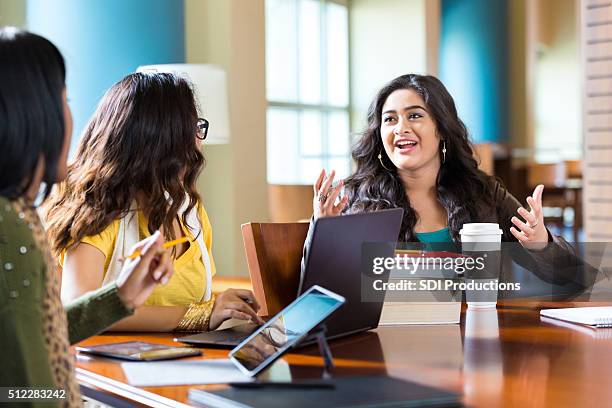 girls studying for high school or college exam in library - gesturing stockfoto's en -beelden