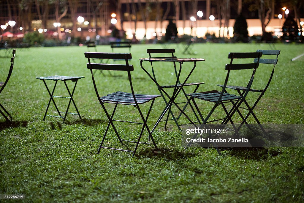 Empty chairs in a park at night
