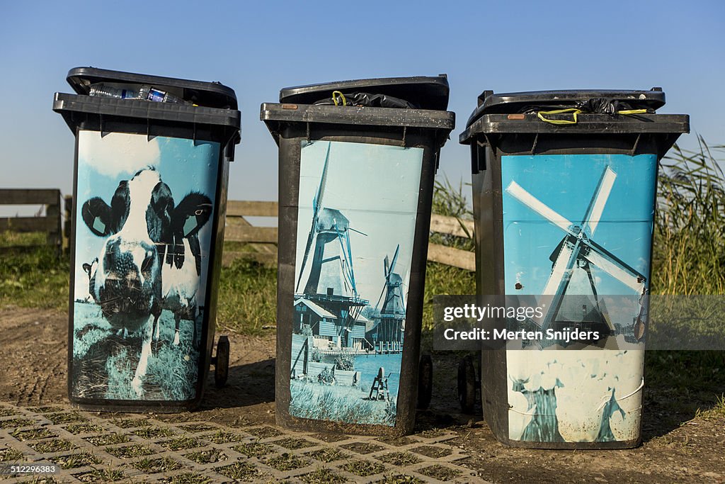 Full garbage bins depicting Dutch icons