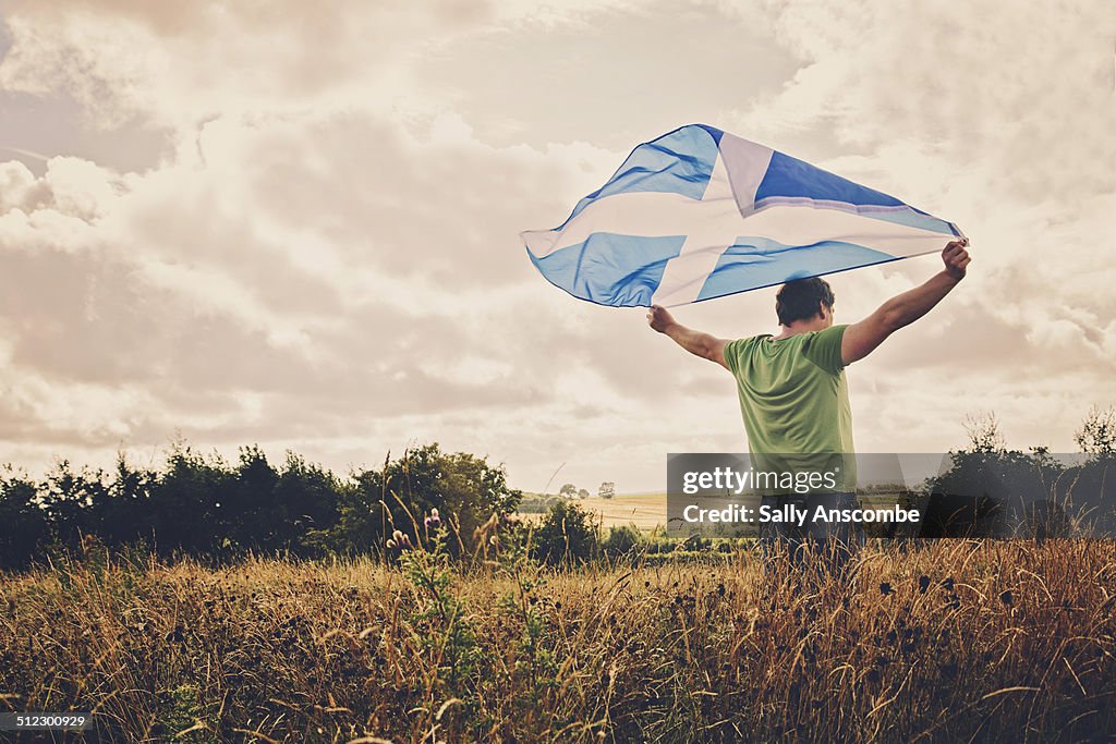 Man holding a Scottish flag
