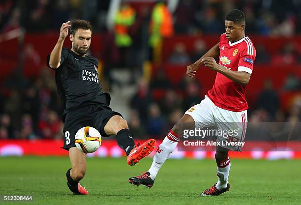 Marcus Rashford of Manchester United and Tim Sparv of FC Midtjylland compete for the ball during the UEFA Europa League Round of 32 second leg match...