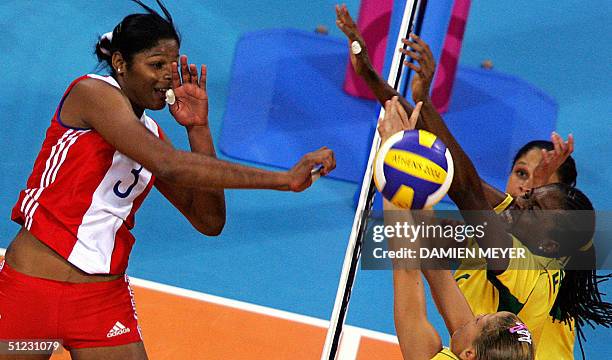 Cuban Nancy Carrillo de la Paz smashes the ball as her Brazilian opponents captain Fernanda Venturini, Fabiana Claudino and Erika Coimbra try to...