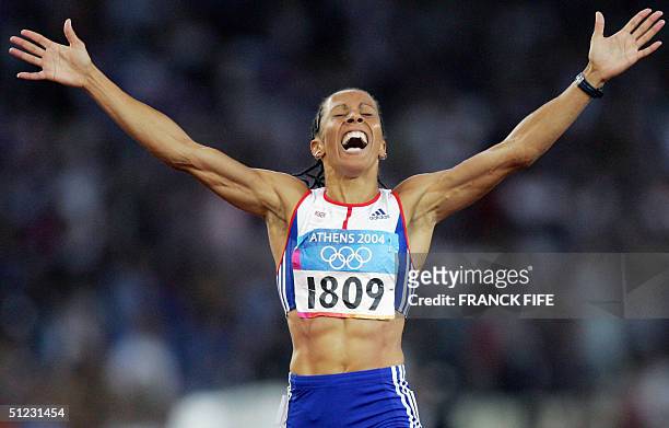 Britain's Kelly Holmes celerbates as she crosses the finish line first for the gold in the women's 1500m final, 28 August 2004, during the Olympic...