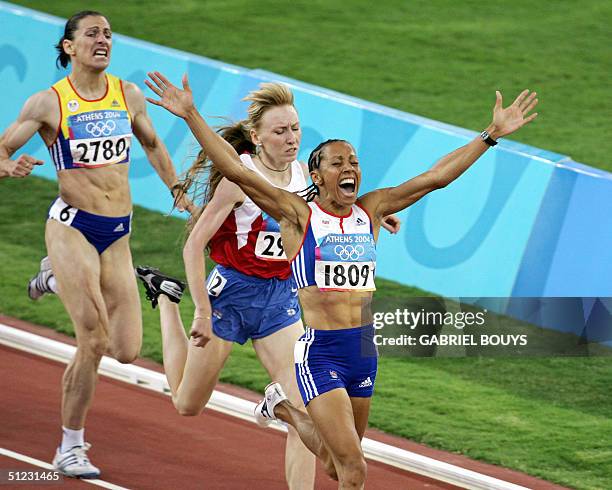 Britain's Keylly Holmes celebrates as she crosses the finish line of the women's 1,500m final ahead of Russia's Tatyana Tomashova and Romania's Maria...