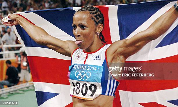 Britain's Kelly Holmes holds up her national flag after she won gold in the women's 1500m final, 28 August 2004, during the Olympic Games athletics...