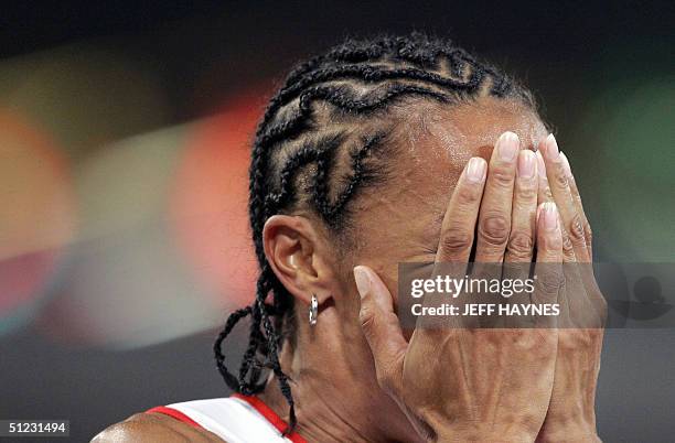 Britain's Kelly Holmes covers her face after she won gold in the women's 1500m final, 28 August 2004, during the Olympic Games athletics competitions...