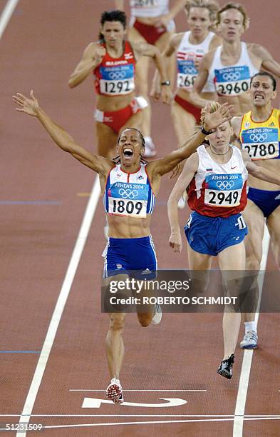 Britain's Kelly Holmes celebrates as she crosses the finish line of the women's 1,500m final ahead of Russia's Tatyana Tomasova and Romania's Maria...