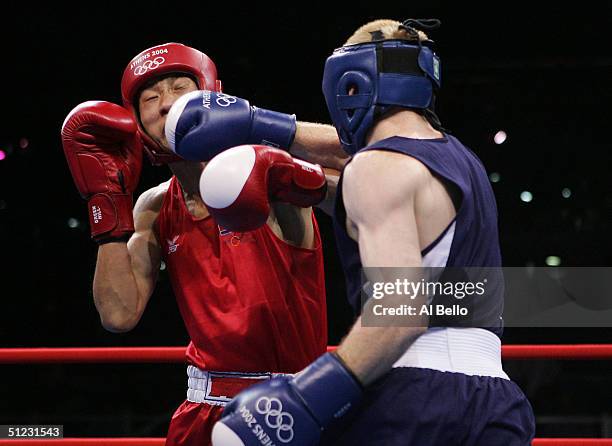 Song Guk Kim of DPR Korea and Alexei Tichtchenko of Russia compete during the men's boxing 57 kg final bout on August 28, 2004 during the Athens 2004...
