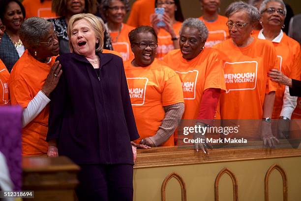 Democratic Presidential candidate, former Secretary of State Hillary Clinton reacts to a supporter's comments before posing for a photo with members...