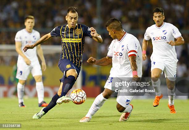 Cesar Delgado of Rosario Central fights for the ball with Diego Polenta of Nacional during a group stage match between Rosario Central and Nacional...