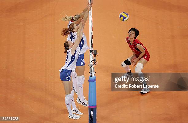 Ping Zhang of China watches as the ball is blocked by Marina Sheshenina, Elizaveta Tishchenko and Lioubov Shashkova of Russia in the women's indoor...