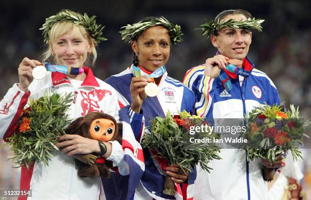 Gold medalist Kelly Holmes of Great Britain, silver medalist Tatyana Tomashova of Russia and bronze medalist Maria Cioncan of Romania celebrate on...