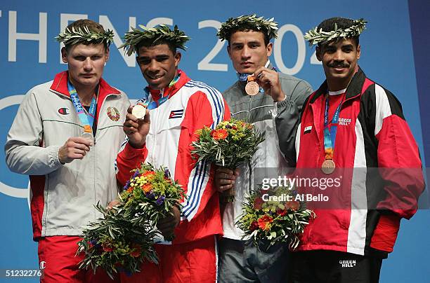 Viktar Zuyev, Odlanier Solis Fonte, Naser Al Shami and Mohamed Elsayed receive their medals during ceremonies for the men's boxing 91kg event on...