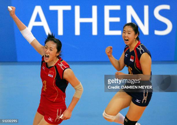 Chinese Liu Yanan and her teammate Zhang Na celebrate their team's victory over Russia at the end of their gold medal volleyball match at the Olympic...