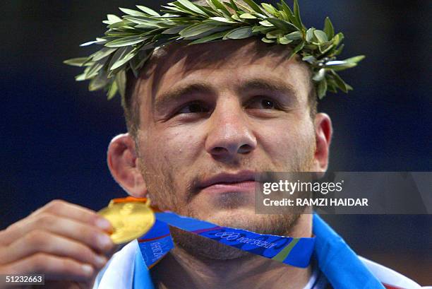 Uzbekistan's Artur Taymazov displays his gold medal in the men's 120 kg free style wrestling competition of the 2004 Olypmic Games in Athens 28...