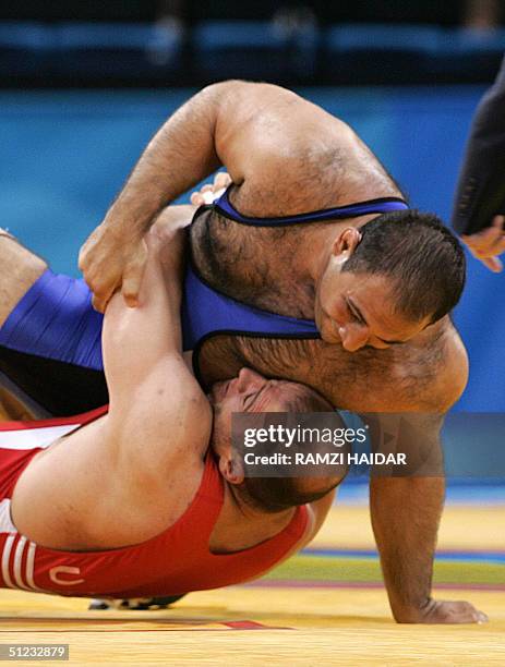 Uzbekhistan's Artur Taymazov fights with Iran's Alireza Rezaei during their men's 120 kg final competition at the 2004 Olypmic Games in Athens 28...