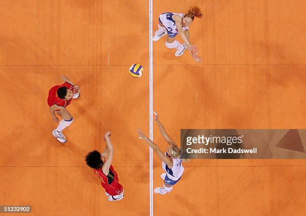 Elizaveta Tishchenko and Lioubov Shashkova of Russia go up to block a shot by Ping Zhang of China in the women's indoor Volleyball gold medal match...