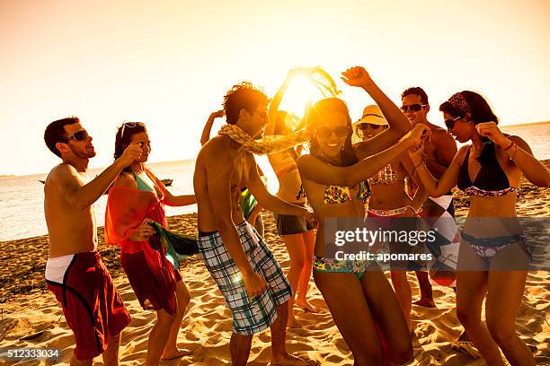 vacaciones de primavera retroiluminación grupo de jóvenes bailando en la playa - caribbean culture fotografías e imágenes de stock