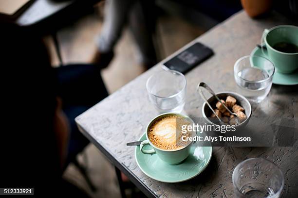 cup of coffee on a table in a cafe - cafe table stock pictures, royalty-free photos & images