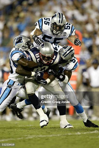 Daniel Graham of the New England Patriots is tackled by Colin Branch, Dan Morgan and Will Witherspoon of the Carolina Panthers on August 28, 2004 at...