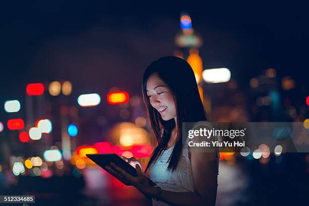 young woman using tablet device in urban city - using digital tablet asian stock pictures, royalty-free photos & images