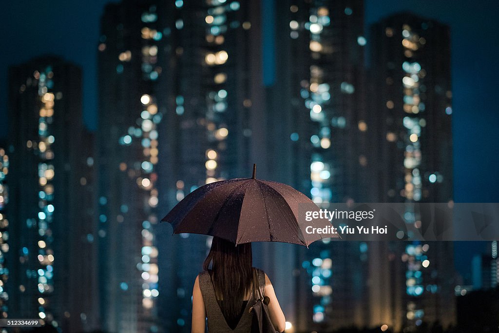 Businesswoman overlooking cityscape on a rainy day