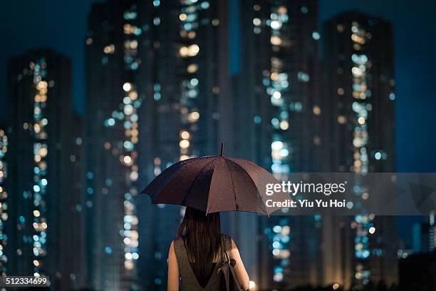 businesswoman overlooking cityscape on a rainy day - protection bildbanksfoton och bilder