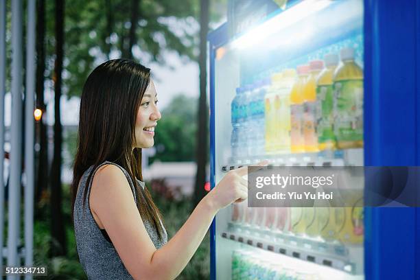 young female choosing drinks from vending machine - vending machine stock pictures, royalty-free photos & images